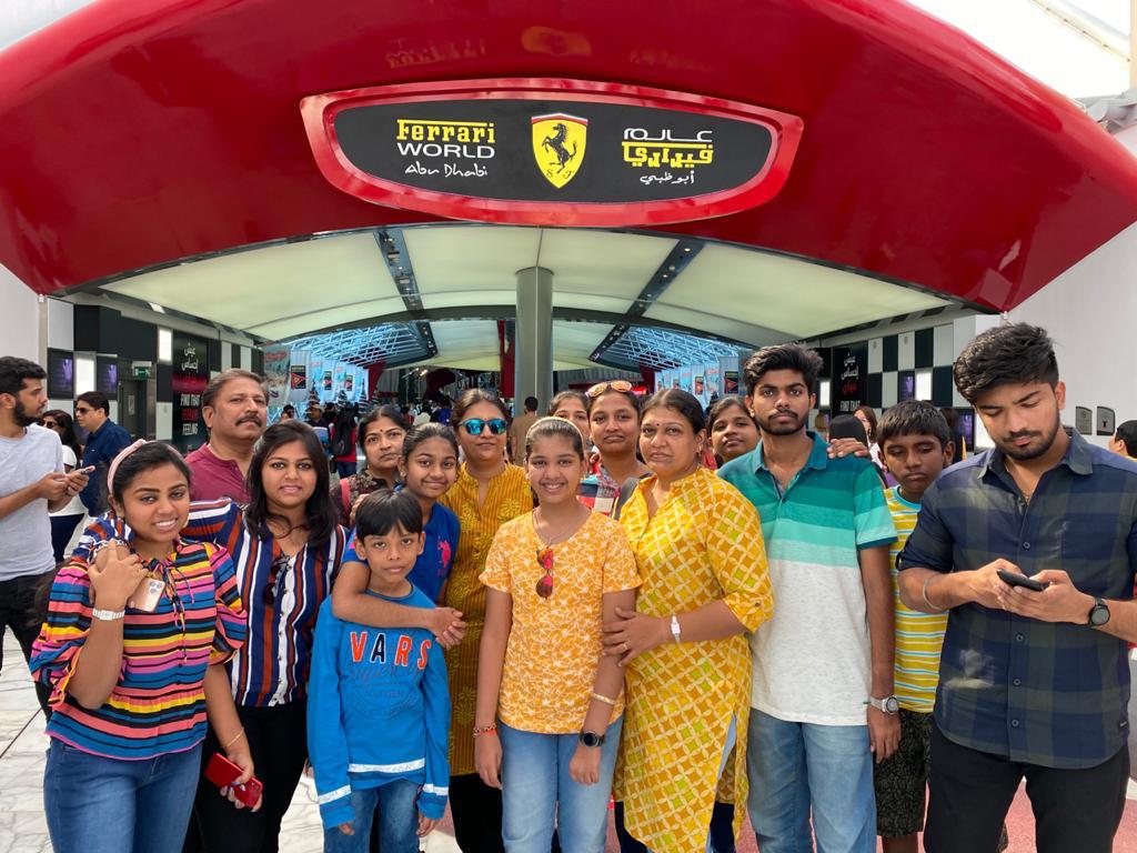 A group of travellers posing together beneath a red entrance canopy