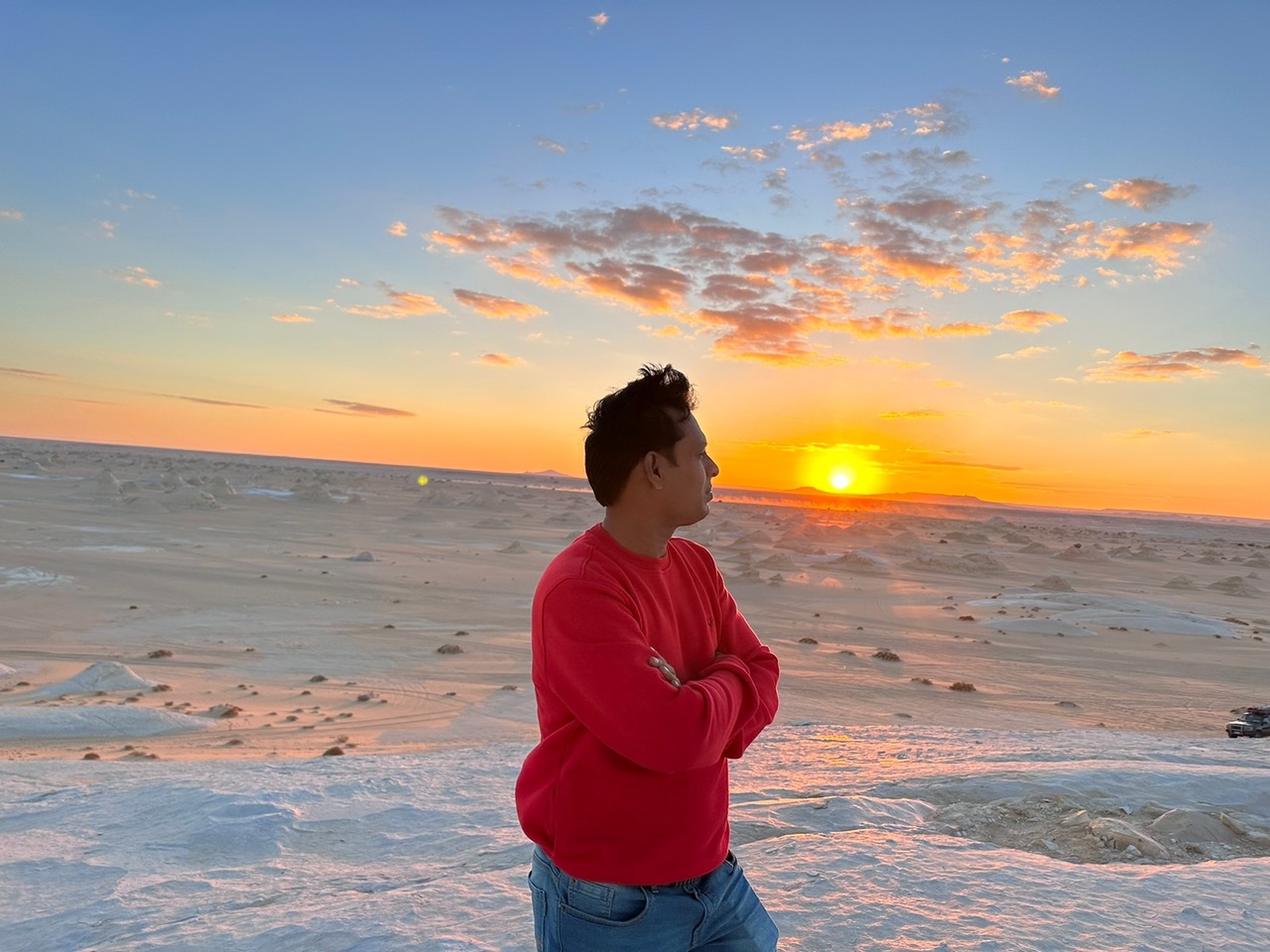 Traveller watching the sunset over a pale desert landscape