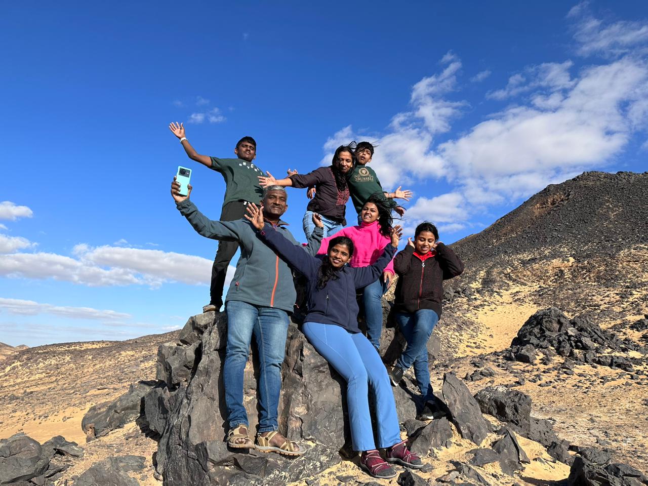 Travellers celebrating together on a rocky mountain